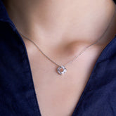 Fine jewellery, silver jewellery, hypoallergenic, tarnish-free, front close-up of a Silver necklace with a diamond pendant on a person wearing a dark blue top.